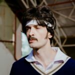 A man in a headband looks like a handsome schmuck, but is probably interesting once you get to know him