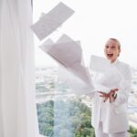 A woman gleefully throws papers in the air freeing herself for a career change